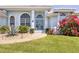 A close up view of a home's exterior showcasing a blue double door and lush landscaping at 11 Amberjack Ln, Placida, FL 33946