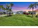 Charming single-story home with lush lawn, mature palm trees, and vibrant flowerbeds at 11 Amberjack Ln, Placida, FL 33946