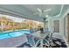 Outdoor patio with table and chairs overlooking the screened-in pool and tropical backyard at 11 Amberjack Ln, Placida, FL 33946
