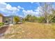 Spacious grassy yard, partially fenced, with mature trees and a screened lanai with pool views at 11008 Waterford Ave, Englewood, FL 34224