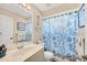 Bathroom with blue fish-themed shower curtain, nautical decor, and a white vanity with a sink at 11008 Waterford Ave, Englewood, FL 34224