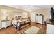 Comfortable bedroom with wood flooring, a patchwork quilt, ample natural light, and classic furnishings at 11008 Waterford Ave, Englewood, FL 34224