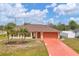 Inviting one-story home with palm trees, a terracotta driveway, and lush lawn at 11008 Waterford Ave, Englewood, FL 34224