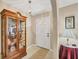 Foyer with tiled floors, white door, decorative hutch and a lamp at 11008 Waterford Ave, Englewood, FL 34224