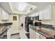 Bright kitchen with stainless steel appliances, granite countertops, white cabinets, and modern fixtures at 11008 Waterford Ave, Englewood, FL 34224