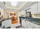 Updated kitchen with stainless steel appliances, granite countertops, white cabinets, and a view of the dining area at 11008 Waterford Ave, Englewood, FL 34224