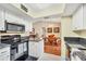 Bright kitchen with stainless steel appliances, granite countertops, white cabinets, and a view to the living room at 11008 Waterford Ave, Englewood, FL 34224