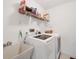 Functional laundry room featuring a modern washer and dryer set, with a utility sink, and shelving at 11008 Waterford Ave, Englewood, FL 34224