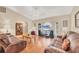 Spacious living room with hardwood floors, leather sofas, and a vaulted ceiling at 11008 Waterford Ave, Englewood, FL 34224