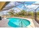 Sparkling screened-in swimming pool with a patio area and a beautiful blue sky overhead at 11008 Waterford Ave, Englewood, FL 34224