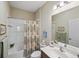 Bright bathroom with a combination bathtub/shower, framed mirror, and decorated with sea-themed decor at 11125 Mcdermott Ct, Englewood, FL 34223