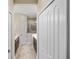 Hallway shows a bathroom with double sinks, a glass door shower, and white wood-look tile floors at 11125 Mcdermott Ct, Englewood, FL 34223