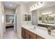 Bathroom with double sinks, large mirrors, and wood cabinets at 11125 Mcdermott Ct, Englewood, FL 34223