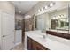 Bathroom features double sinks, tile floors, a shower with glass doors, and modern lighting at 11125 Mcdermott Ct, Englewood, FL 34223