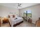 Light bedroom with a large window overlooking the yard and tray ceiling with ceiling fan at 11125 Mcdermott Ct, Englewood, FL 34223