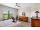 Light bedroom with a large window overlooking the yard and tray ceiling with ceiling fan at 11125 Mcdermott Ct, Englewood, FL 34223