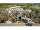 Aerial view of a beautifully landscaped clubhouse with palm trees and circular driveway at 11125 Mcdermott Ct, Englewood, FL 34223