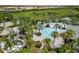 Aerial shot of a resort-style community pool surrounded by lush landscaping and ample seating at 11125 Mcdermott Ct, Englewood, FL 34223