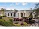 Elegant single-story home with arched windows and meticulously landscaped front yard with colorful plants at 11125 Mcdermott Ct, Englewood, FL 34223