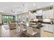 Bright and airy kitchen with an island, stainless appliances, white cabinetry, and an open layout connected to the living space at 11125 Mcdermott Ct, Englewood, FL 34223