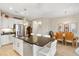 Spacious kitchen with an island, stainless steel appliances, white cabinets, and an adjacent dining area for seamless entertaining at 11125 Mcdermott Ct, Englewood, FL 34223