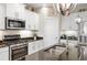 Bright kitchen features stainless steel appliances, granite countertops, and white cabinets at 11125 Mcdermott Ct, Englewood, FL 34223