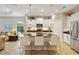 Stylish kitchen featuring a large island with bar seating, stainless steel appliances, and a seamless flow into the living area at 11125 Mcdermott Ct, Englewood, FL 34223