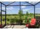 Relaxing screened-in lanai with comfortable seating and picturesque views of the natural surroundings at 11125 Mcdermott Ct, Englewood, FL 34223