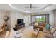 Comfortable living room with tray ceilings, a ceiling fan, and a view of the lanai at 11125 Mcdermott Ct, Englewood, FL 34223