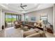 Spacious living room with a ceiling fan, large sectional couch, and sliding glass doors at 11125 Mcdermott Ct, Englewood, FL 34223