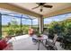 Enjoy outdoor living on this screened patio with seating, providing serene views and a perfect spot for entertaining or relaxation at 11125 Mcdermott Ct, Englewood, FL 34223