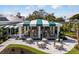 Outdoor patio area featuring seating under a pergola-style structure with striped awning at 11125 Mcdermott Ct, Englewood, FL 34223