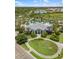 Aerial view of a community pool and clubhouse with manicured landscaping, sidewalks, and water views at 11125 Mcdermott Ct, Englewood, FL 34223