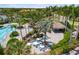 Community pool area featuring a tiki bar, swimming pool, tables, chairs, and lush landscaping with palm trees at 11125 Mcdermott Ct, Englewood, FL 34223