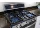 Stainless steel gas range stove top with dark granite countertops in a modern kitchen at 11125 Mcdermott Ct, Englewood, FL 34223