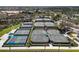Overhead shot of various tennis courts with lush greenery and nearby parking at 11125 Mcdermott Ct, Englewood, FL 34223