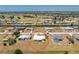 Aerial view of a white roofed home in a neighborhood near canals and golf courses surrounded by lush landscapes at 113 Annapolis Ln, Rotonda West, FL 33947