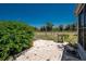 Paver patio in a fenced backyard, featuring well-maintained landscaping, a vibrant bush, and a clear blue sky above at 113 Annapolis Ln, Rotonda West, FL 33947