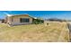Spacious backyard with ample green space, complemented by the home's exterior and a simple chain-link fence at 113 Annapolis Ln, Rotonda West, FL 33947