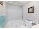 Tiled shower and toilet with a framed picture and colorful patterned wallpaper at 113 Annapolis Ln, Rotonda West, FL 33947