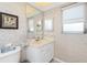 Vanity with mirror, window, neutral wallpaper, and view into bedroom at 113 Annapolis Ln, Rotonda West, FL 33947