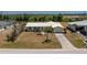 Inviting single-story home with a tidy front yard, concrete driveway and mature landscaping in the front at 113 Annapolis Ln, Rotonda West, FL 33947