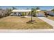 Charming single story home with light yellow paint, white roof, blue shutters and green lawn at 113 Annapolis Ln, Rotonda West, FL 33947