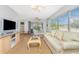 Open-concept living space with comfortable couch, television, glass table and seamless access to outdoor patio at 113 Annapolis Ln, Rotonda West, FL 33947