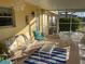 Bright sunroom featuring comfortable seating, a glass table, and outdoor access at 113 Annapolis Ln, Rotonda West, FL 33947
