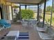 Covered sunroom with casual seating, white wrought-iron furniture and screening at 113 Annapolis Ln, Rotonda West, FL 33947