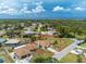 An aerial view shows the home's location within a verdant, well-treed neighborhood and proximity to water at 1155 Osceola Blvd, Englewood, FL 34223