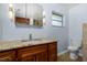 This bathroom features a gorgeous wooden vanity with granite countertop and a toilet at 1155 Osceola Blvd, Englewood, FL 34223