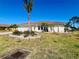 Charming single-story home with an attached garage and tropical landscaping in the front yard at 1155 Osceola Blvd, Englewood, FL 34223
