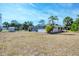 Expansive backyard showcasing a screened-in patio and mature palm trees under blue skies at 11869 Newgate Ave, Port Charlotte, FL 33981